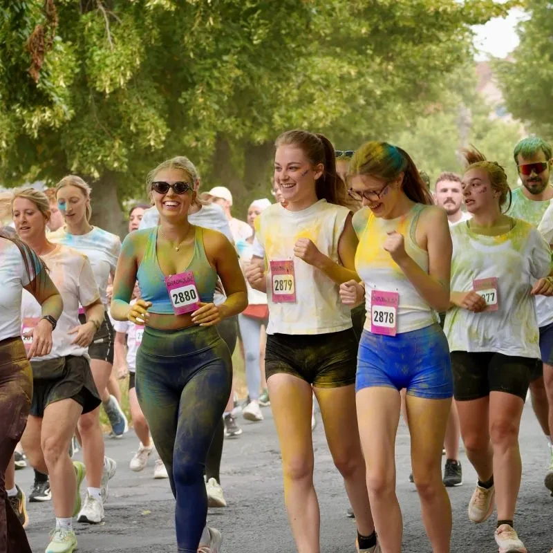 Un groupe de coureurs, couverts de poudre colorée